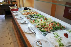 Buffet-Tisch im Irene Palace Beach Resort mit verschiedenen Salaten und Gerichten.