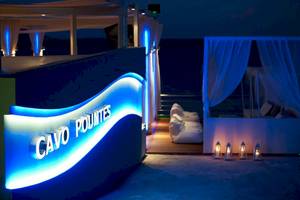 Terrasse des Proteas Blu Resorts mit blauen Lichtern und einem Schild, das 'Cavo Pountes' in weißer Schrift auf blauem Hintergrund beleuchtet.