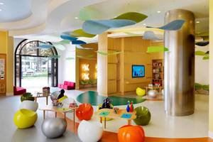 Kinderbereich im Ritz Carlton Abu Dhabi Grand Canal mit bunten Sitzmöbeln und Spielzeug.