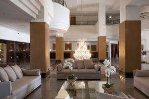 Empfangsbereich des Venus Beach Hotels mit moderner Einrichtung und zentralem Kronleuchter.