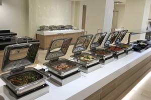 Buffet-Tisch im Aphrodite Beach Club Hotel mit verschiedenen Speisen in Silberschüsseln.