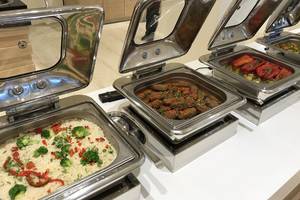 Im Aphrodite Beach Club sind mehrere Edelstahl-Buffet-Gefäße mit verschiedenen Gerichten zu sehen.