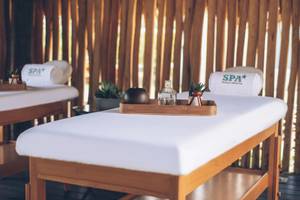 Spa-Behandlungsraum im Iberostar Costa Dorada Hotel mit zwei Massagetischen und Spa-Zubehör.
