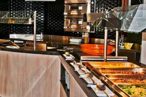 Buffetbereich im BQ Apolo Hotel mit Speisen, Geschirr und Küchengeräten.