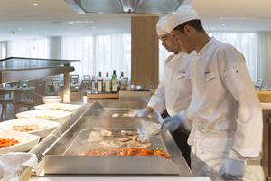 Chefs bereiten Essen in der Küche des HSM Linda Playa Hotels zu.