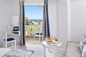 Innenansicht eines Zimmers im Mrs Chryssana Beach Hotel mit Blick auf den Balkon und das Meer.