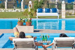 Zwei Leute entspannen sich im Swimmingpool des Mrs Chryssana Beach Hotels.