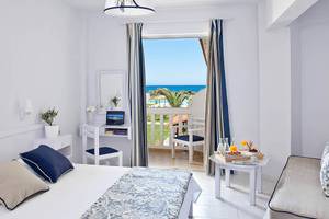 Zimmer im Mrs Chryssana Beach Hotel mit Balkon, Schreibtisch und Meerblick.