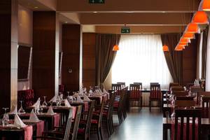 Restaurant des Megasaray Club Belek mit gedeckten Tischen und Stühlen.