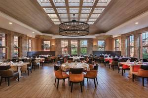 Innenansicht des Restaurants im Megasaray Club Belek mit Holzboden und Tischdekoration.