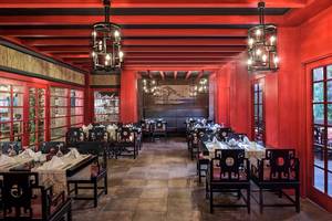 Innenansicht des Restaurants im Megasaray Club Belek mit roten Wänden und traditionellen chinesischen Möbeln.