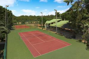 Tennisplatz im Megasaray Club Belek mit grünen Rasenflächen und roten Spielfeldern.