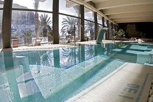 Innenpool im LIVVO Costa Taurito Hotel mit blauem Wasser und blau-weißen Kacheln.