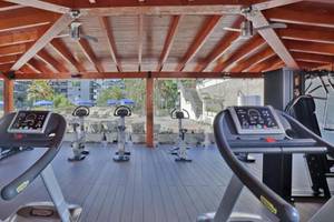 Fitnesscenter im Barcelo Margaritas Hotel mit Laufbändern und anderen Geräten unter einem Pavillon.