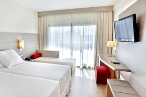 Doppelzimmer im Barcelo Margaritas Hotel mit zwei Betten, einem Sofa, einem Schreibtisch und einem Fernseher.