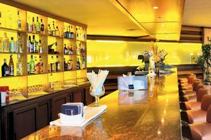 Innenansicht der Bar im Barcelo Fuerteventura Mar Hotel mit Bartheken, gefüllten Flaschen und Lederstühlen.