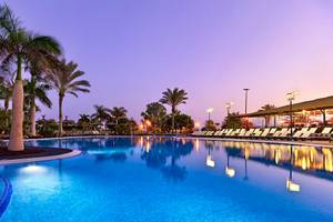 Außenpool des Barcelo Fuerteventura Mar Hotels bei Nacht mit Lounge-Liegen und Palmen
