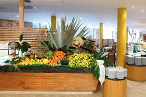 Buffetbereich im Barcelo Fuerteventura Mar Hotel mit vielen Früchten und gestapelten Tellern.