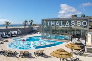 Außenpool des Barcelo Fuerteventura Mar Thalasso Hotel mit Loungeliegen und Sonnenschirmen.