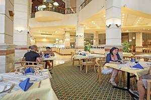 Gäste sitzen an Tischen im Restaurant des Akassia Swiss Resort.