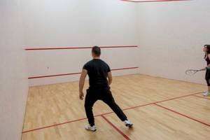 Ein Mann und eine Frau spielen Squash im AX Odycy Hotel.
