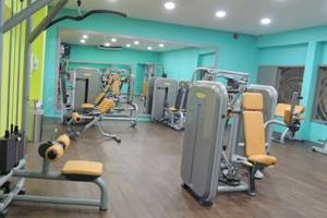 Fitnessstudio im Seashells Resort at Suncrest mit blauen Wänden und gelben Trainingsgeräten.