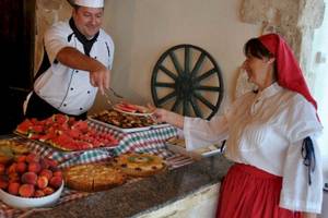 Ein Koch im Seashells Resort serviert einer Frau ein Buffet mit Wassermelonen, Obst und Kuchen.
