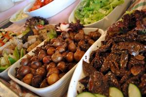 Buffet mit verschiedenen Gerichten im Seashells Resort at Suncrest, einschließlich Salaten, Bohnen und Fleisch.
