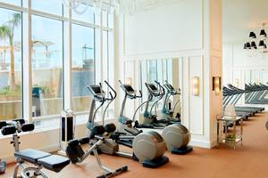 Fitnessstudio im St. Regis Abu Dhabi mit modernen Geräten und großen Fenstern.