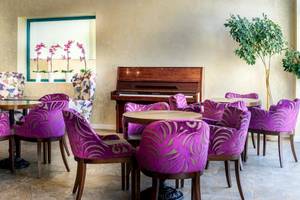 Loungebereich im Marina Grand Beach Hotel mit Klavier, Stühlen und Tisch