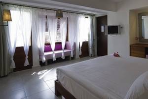 Schlafzimmer im Hillside Beach Club Hotel mit großem Bett, Fenstern und Wanddekor