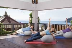 Drei Personen, die Yoga auf Exercise-Bällen auf dem Balkon des Hillside Beach Club machen.