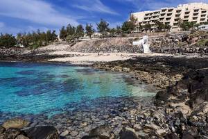 Strand mit klarem Wasser und Felsen am Barcelo Lanzarote Active Resort