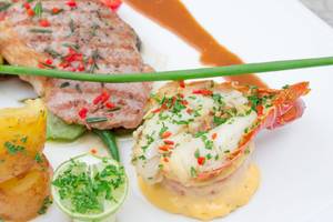 Ein Teller mit gegrilltem Steak, Hummer, Kartoffeln und Gemüse im Beyond Resort Krabi.