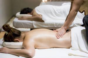Massagebehandlung im Beyond Resort Krabi, bei der eine Frau Rückenmassage bekommt.