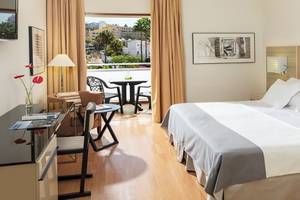 H10 Gran Tinerfe Hotelzimmer mit Balkon, Bett, Tisch und Stühlen.