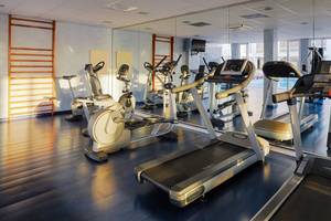 Fitnessraum im H10 Gran Tinerfe Hotel mit Laufbändern, Fahrradtrainern und anderen Geräten.