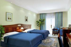 Doppelzimmer im Stella Gardens Resort & Spa Makadi Bay mit zwei Betten, Schreibtisch, Fernseher und Pflanzen.