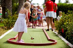 Ein kleines Maedchen spielt Minigolf im Freien im Hotel El Mouradi Djerba Menzel.