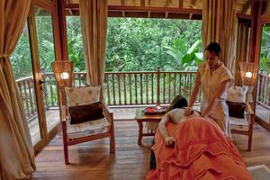 Frau im Cerf Island Resort genießt eine Massage auf dem Balkon mit Blick auf den Regenwald