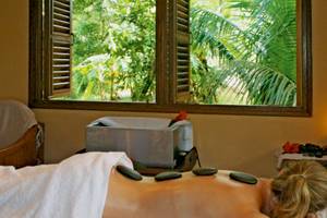 Eine Frau erhält eine Massage im Hotel Cerf Island Resort mit Blick auf den Garten.