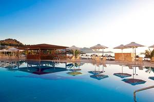 Pool-Terrasse des Lindos Bay Hotels mit Sonnenschirmen und Liegen am Meer