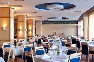 Innenbereich des Lindos Bay Hotels mit eingerichteten Tischen und Stühlen.