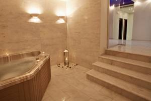 Jacuzzi-Bereich im Silva Beach Hotel mit Marmorwänden und Beleuchtung.