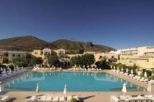Außenpool des Silva Beach Hotels mit Sonnenliegen und Berg im Hintergrund