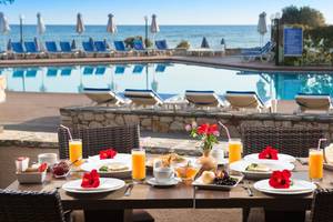 Frühstückstisch am Pool im Silva Beach Hotel mit Blick auf das Meer.