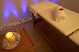 Relaxationsbereich im Silva Beach Hotel mit Massageliege, Kerze und Steinen