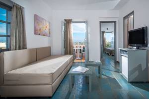 Innenansicht eines Zimmers im Silva Beach Hotel mit Sofa, Fernseher und Tisch.