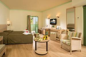 Innenansicht eines Doppelzimmers im Silva Beach Hotel mit zwei Betten, einem Tisch und einem Fernseher.