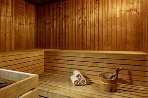 Eine Holzsauna im Grecian Park Hotel mit Holzbänken und Handtüchern.